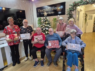 Residents of Thornhill House Care Home holding Christmas shoeboxes.