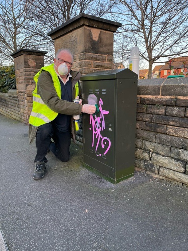 ISSUE: Coun Philip Wright removing the graffiti.