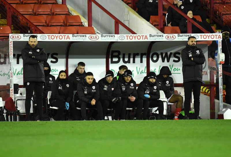 Martin Devaney, left on Barnsley's bench against Barrow