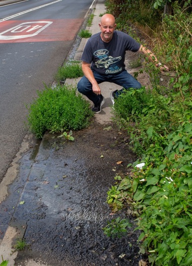 LEAK: Coun Andy Wray at the spot where the sewage leaks onto the road. Picture Shaun Colborn PD094278