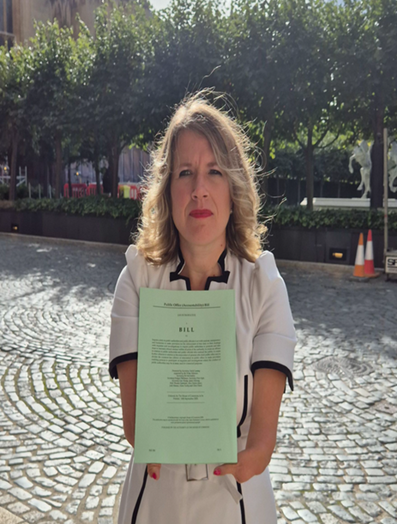 Marie Tidball MP holding the Public Office (Accountability) Bill in Parliament.