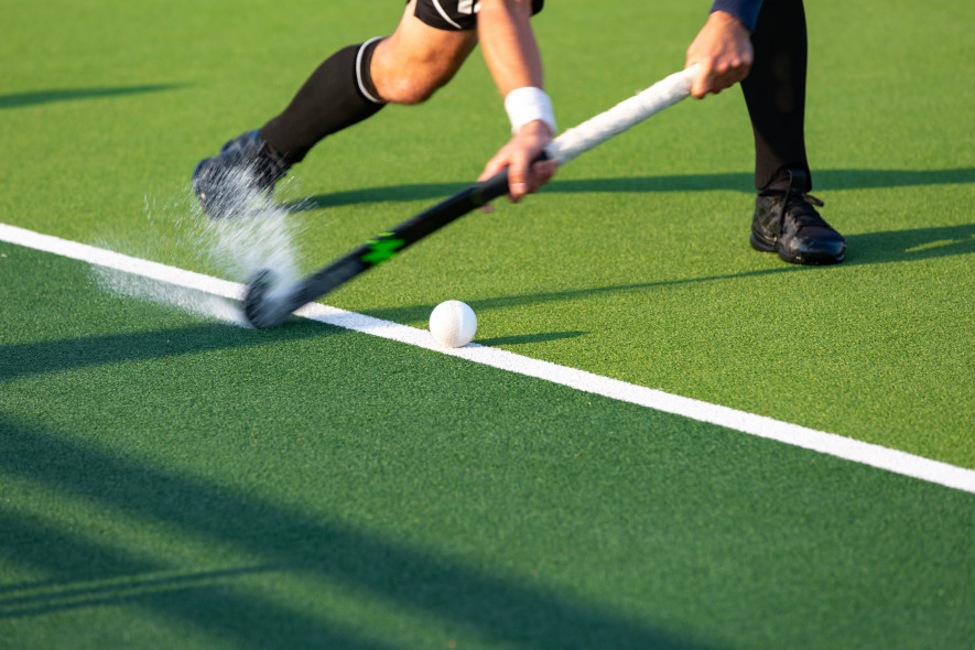 Hockey, hockey stick about to strike ball, players lower legs only Stock Image